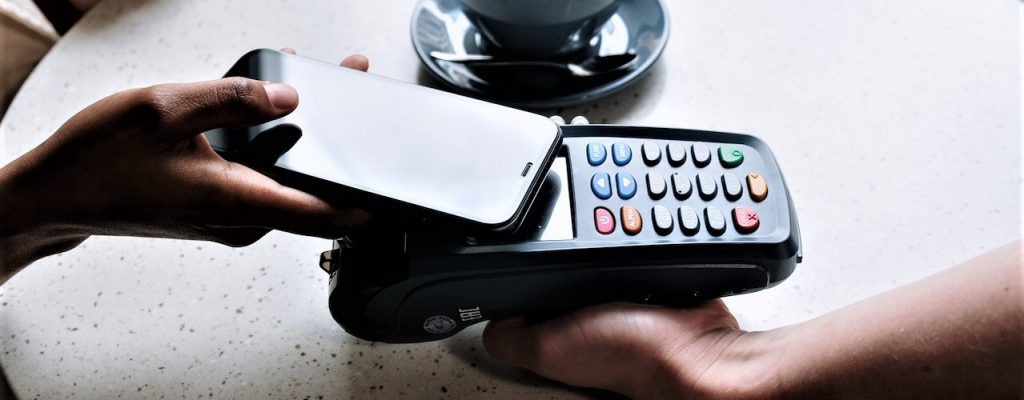 person using phone to make payment on POS system